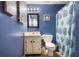 Bathroom with blue walls, patterned shower curtain, and framed mirror above vanity at 3747 Junior Ln, Douglasville, GA 30135