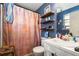 Bathroom with blue walls, pink shower curtain, and storage shelves above toilet at 3747 Junior Ln, Douglasville, GA 30135