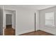 Bedroom with grey walls and brown floors, a window and closet with doors open to reveal other room at 1132 Fair St, Atlanta, GA 30314