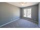 A carpeted bedroom with neutral walls and a window providing natural light at 2037 Castlemaine Circle, Woodstock, GA 30189
