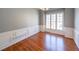 Dining room featuring hardwood floors, wainscoting, neutral walls, and three-casement windows at 2037 Castlemaine Circle, Woodstock, GA 30189