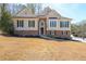 Charming home featuring beige siding accented by stacked stone, complemented by a well-manicured lawn at 2037 Castlemaine Circle, Woodstock, GA 30189