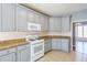 Well-lit kitchen with light gray cabinets, white appliances, and light brown countertops at 2037 Castlemaine Circle, Woodstock, GA 30189