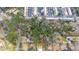 A high-angle aerial view shows a dense wooded neighborhood near townhomes, and single Gathering residences at 2469 Stone Rd, East Point, GA 30344