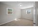 A neutral-toned bedroom has two windows letting in sunlight and carpeted flooring at 708 Morris Rd, Hiram, GA 30141