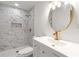 Modern bathroom featuring marble tile, a glass-enclosed shower, and sleek gold fixtures and mirror at 1894 Evans Sw Dr, Atlanta, GA 30310