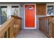 Close-up of a vibrant orange front door with wood accents and a charming, welcoming entrance at 1894 Evans Sw Dr, Atlanta, GA 30310