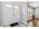 Inviting entryway featuring a double door, tile flooring, and view into a room with wood floors and bright window at 6274 Katelyn Park, Lithonia, GA 30058