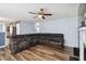 Large living room offering wood flooring, a ceiling fan, and an expansive sectional sofa with a view of the staircase at 6274 Katelyn Park, Lithonia, GA 30058