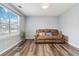 Cozy living room with new wood flooring, natural light from a bright window, and a comfortable reclining sofa at 6274 Katelyn Park, Lithonia, GA 30058