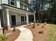 Home's front entrance features a mulch bed, a walkway to the covered porch, and new landscaping at 75 Pine Creek Ct, Dallas, GA 30157