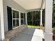 Covered front porch with white pillars, brick accents, and dark shutters at 75 Pine Creek Ct, Dallas, GA 30157