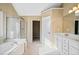 Bright bathroom featuring a soaking tub, glass shower, and a vanity with white cabinets at 217 Park Creek Dr, Woodstock, GA 30188