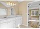 Bathroom with double vanity, large mirror, and an open doorway to a room with wood flooring at 217 Park Creek Dr, Woodstock, GA 30188
