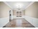 Elegant dining room with wood-look floors, wainscoting, and a stylish chandelier at 217 Park Creek Dr, Woodstock, GA 30188