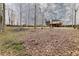 An expansive backyard featuring mature trees, a wooden fence, and a sloped landscape at 4020 F A A Rd, Cumming, GA 30041