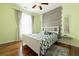 Comfortable bedroom showcasing a decorative wooden accent wall, hardwood floors, and a ceiling fan at 4020 F A A Rd, Cumming, GA 30041