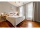 Comfortable bedroom showcasing hardwood floors, a ceiling fan, and abundant natural light streaming through two large windows at 4020 F A A Rd, Cumming, GA 30041