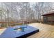 Back deck with hot tub and wooded view, perfect for relaxing outdoors at 4020 F A A Rd, Cumming, GA 30041