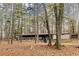 Exterior view of a rustic lakeside building with a covered porch, nestled in a wooded area at 4020 F A A Rd, Cumming, GA 30041