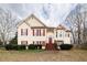 Charming two-story home featuring red shutters, yellow siding, a front porch, and manicured landscaping at 4020 F A A Rd, Cumming, GA 30041