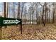 Parking sign with arrow pointing towards a wooded area and a glimpse of the lake at 4020 F A A Rd, Cumming, GA 30041