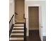 Staircase leading to the upper level, featuring dark wood and access to a storage area at 4191 Wisconsin Dr, Dunwoody, GA 30338