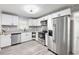 Modern kitchen with stainless appliances, granite countertops, mosaic backsplash and white cabinetry at 4611 Old Westside Rd, Austell, GA 30106