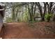 Large backyard featuring mature trees, dirt, and some patio space for outdoor enjoyment at 4938 Terrace Green Trce, Stone Mountain, GA 30088