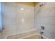 Tiled bathtub with built in seat and mounted shower head, features white tile and silver fixtures at 4938 Terrace Green Trce, Stone Mountain, GA 30088