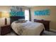 Bedroom with queen-sized bed, bedside table, dresser, and decorative blue floral wall art at 4938 Terrace Green Trce, Stone Mountain, GA 30088