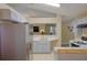 Kitchen with stainless steel refrigerator, light cabinets and countertops, open to another living area at 4938 Terrace Green Trce, Stone Mountain, GA 30088