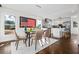 Open dining area with hardwood floors and modern lighting adjacent to kitchen with gray backsplash at 2120 Blaylock Dr, Marietta, GA 30062