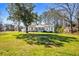 Expansive lawn view of charming home featuring a white exterior, lush green lawn, and mature trees at 2120 Blaylock Dr, Marietta, GA 30062