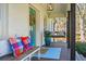 Inviting front porch with a bench, swing, colorful pillows, potted flowers, and a blue rug at 2120 Blaylock Dr, Marietta, GA 30062