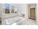 Bright bathroom with a large soaking tub under a window and a glass-enclosed shower, creating a spa-like atmosphere at 332 William Dr, Canton, GA 30114