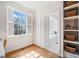 Bright bedroom featuring hardwood floors, a large window with shutters, and built-in shelving, offering a cozy and functional space at 332 William Dr, Canton, GA 30114