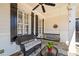 Relaxing front porch showcasing a bench swing, ceiling fan, and stone flooring at 332 William Falls Dr, Canton, GA 30114