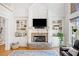 Living room with stone fireplace, built-in shelves, and large windows offering backyard views at 332 William Falls Dr, Canton, GA 30114