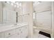 Bright bathroom features a large mirror, white cabinets, and a shower-tub combination with glass doors at 332 Williamfalls Dr, Canton, GA 30114