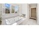 Well-lit bathroom featuring a large soaking tub and glass-enclosed shower at 332 Williamfalls Dr, Canton, GA 30114