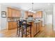 Bright kitchen featuring wood cabinets, granite countertops, kitchen island with barstool seating, and hardwood floors at 332 Williamfalls Dr, Canton, GA 30114