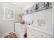 Clean laundry room with white washer and dryer, white cabinets, sink, and wire shelving for organized storage at 332 Williamfalls Dr, Canton, GA 30114