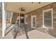 Covered patio with stone walls, metal table and chairs, and ceiling fan at 332 Williamfalls Dr, Canton, GA 30114