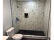 Elegant bathroom featuring a walk-in shower with stylish black and white marble-patterned tiles at 684 S Hairston Rd, Stone Mountain, GA 30088