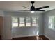 Light and airy bedroom with hardwood floors, a ceiling fan, and several large windows at 684 S Hairston Rd, Stone Mountain, GA 30088