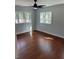 Bedroom with hardwood floors, ceiling fan, and natural light from multiple windows at 684 S Hairston Rd, Stone Mountain, GA 30088