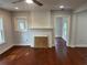 Living room with beautiful hardwood floors and freshly painted white brick fireplace at 684 S Hairston Rd, Stone Mountain, GA 30088