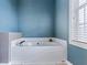A soaking tub area is accented by blue walls, blinds and natural lighting at 4612 Liberty Square Dr, Acworth, GA 30101