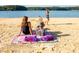 A Gathering enjoys a sunny day at the beach by a serene lake, swimming, relaxing, and playing games at 4755 Fowler St, Acworth, GA 30101